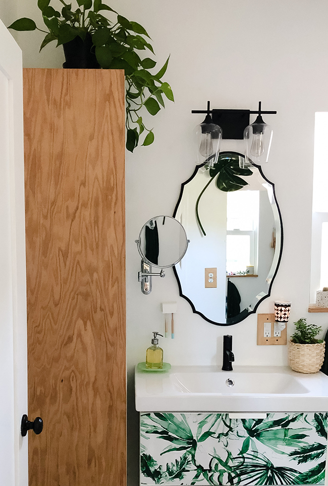 White and black bathroom, Wood door, leaves on vanity