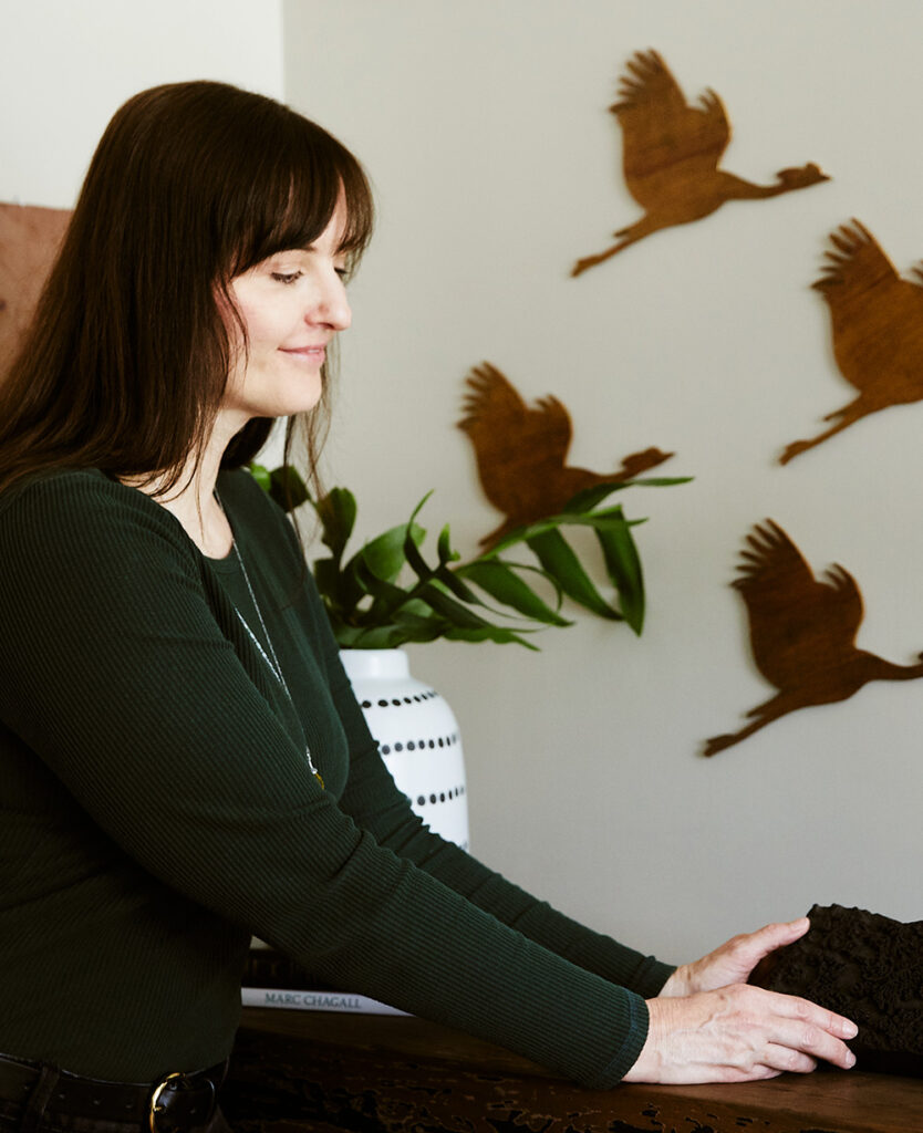 Rebecca move a black brick, wood birds on wall, white black dot vase with plants